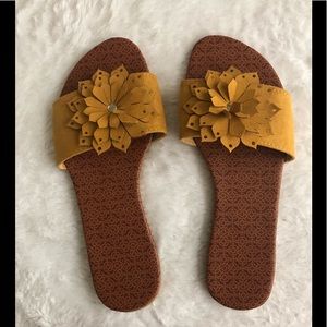 A pair of sandals with 🌼 yellow flower